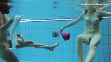 Two girls swim naked underwater